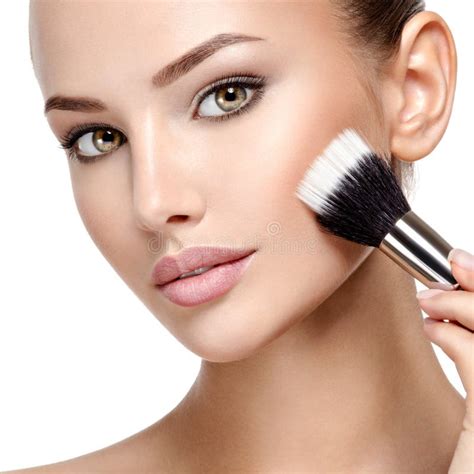 Woman Applying Cosmetic Makeup On The Face With Brush Stock Photo