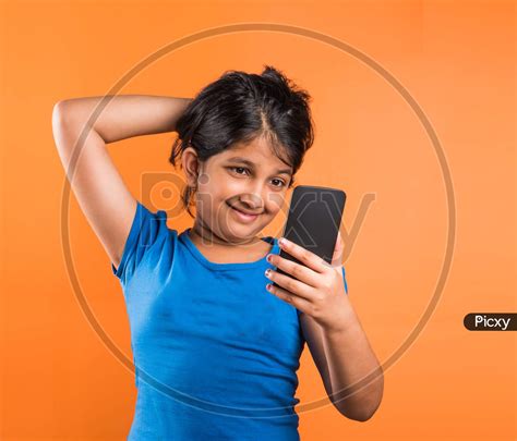 Image Of Small Girl Using Smartphone For Playing Game Or Taking Selfie
