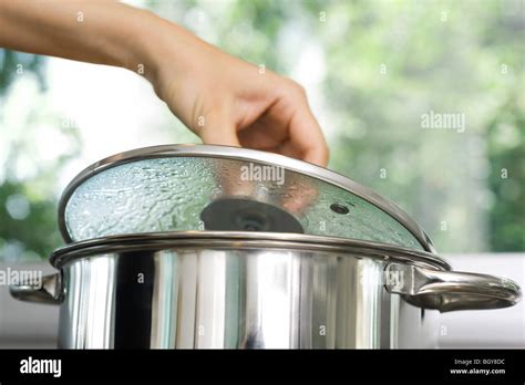 Person Removing Lid From Cooking Pot Stock Photo Alamy