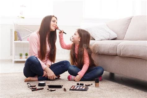 Madre E Hija Que Hacen El Maquillaje Que Se Sienta En El Piso Foto De