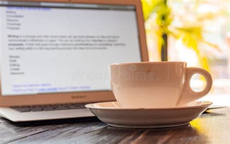 A Cup Of Coffee Against A Laptop Screen Writing A Journal Concept