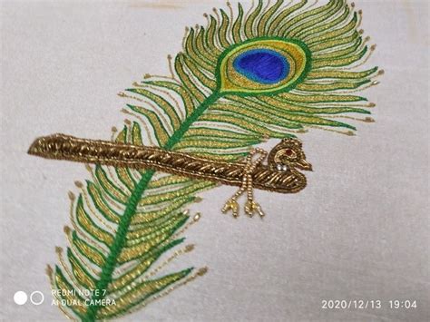 A Close Up Of A Peacocks Tail On A Piece Of Cloth With Gold Thread