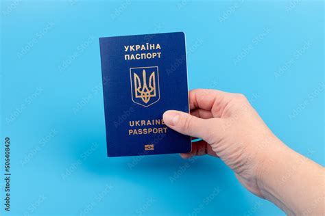 Passport Of A Citizen Of Ukraine In A Female Hand On A Blue Background Close Up Inscription In