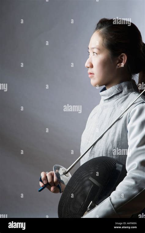 Side Profile Of A Female Fencer Holding A Sword And A Fencing Mask Stock Photo Alamy