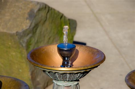 A Metal Bowl With A Blue Faucet In It
