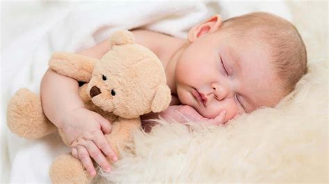 Baby Is Sleeping On Sandal Color Textile Covered With White Towel And