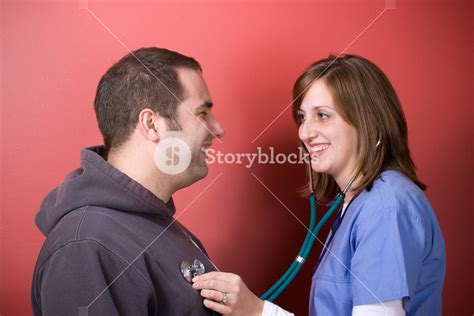A Young Doctor Or Nurse Listening To The Heartbeat Of Her Patient With