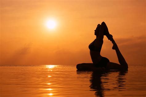 Silhouette Young Woman Practicing Yoga On The Beach At