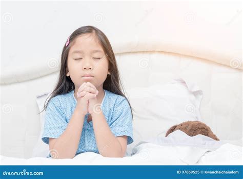 Little Girl Praying On Bed Spirituality And Religion Stock Image