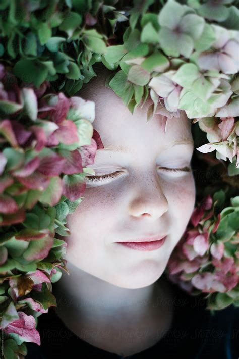 A Beautiful Child With Her Eyes Closed And Her Face Surrounded By