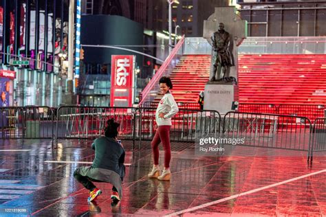 People Pose For Photos In The Emptiness At Times Square During The