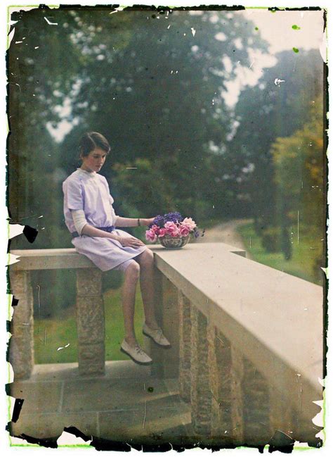 A Woman Sitting On A Ledge With Flowers