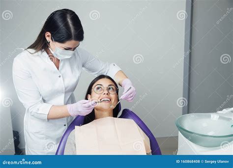 A Woman Is Preparing For A Dental Examination Woman Having Teeth Examined At Dentists Stock