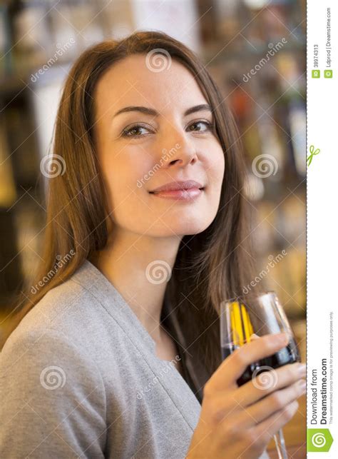 Portrait Of Pretty Young Woman Drinking Red Wine In Restaurant Stock