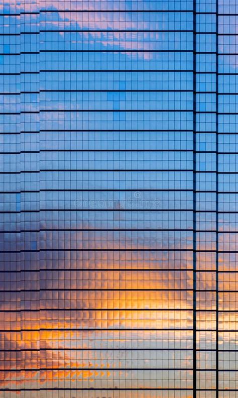 The Building Covers With Glasses That Have Reflection From Dusk Sky