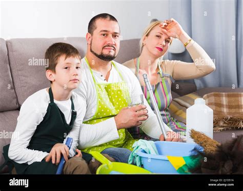 Tired Parents With Son Dressed For Cleaning Stock Photo Alamy