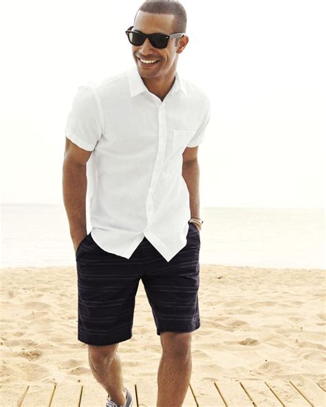 For a laid back but still stylish beach wedding attire for men, combine a pair of tailored (as opposed to more casual draw string) white linen pants, a crisp tailored shirt (striped will look very nice or else something like the white shirt featured in the picture. Summertime Swagger: How to Dress for the Heat