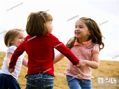 Three Girls Playing And Holding Hands Outdoors Stock Photo Picture