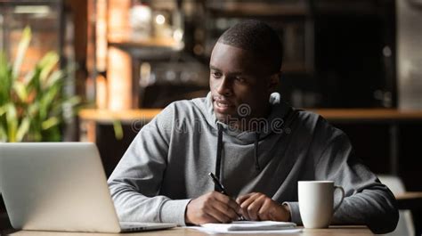 Focused Young Man Studying With Laptop Make Notes In Cafe Stock Photo