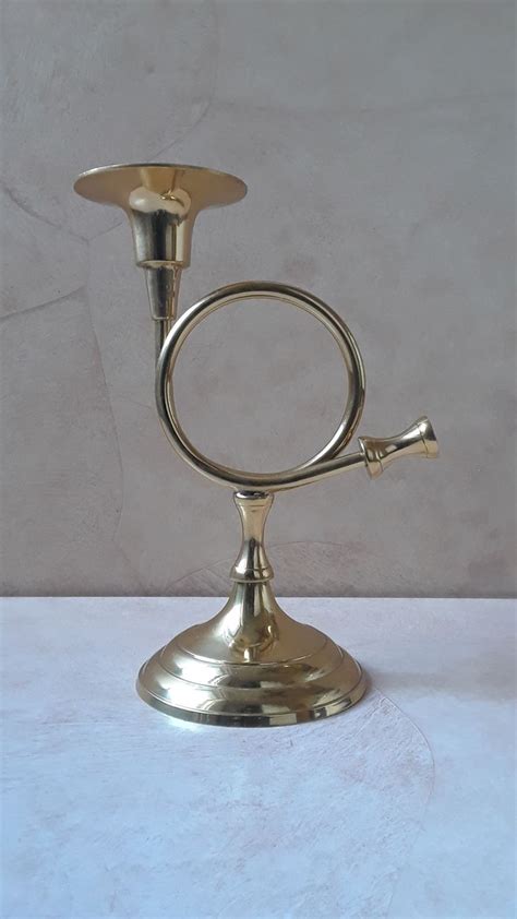 A Brass Candle Holder On A White Table