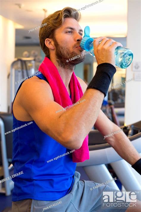 Man Drinking Water From A Bottle In A Gym Stock Photo Picture And