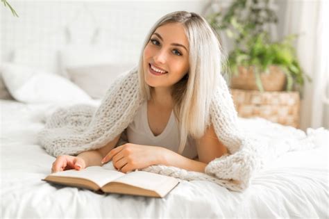 Premium Photo Beautiful Young Woman Lies On A Bed With A Book