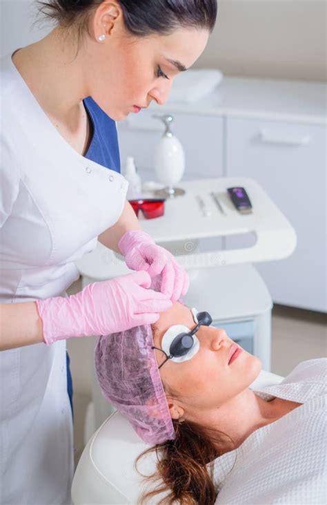 Young Woman Receiving Laser Treatment In Cosmetology Clinic Eyes Covered With Protection