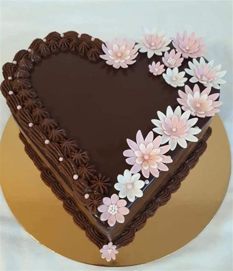 A Heart Shaped Chocolate Cake With Flowers On Top