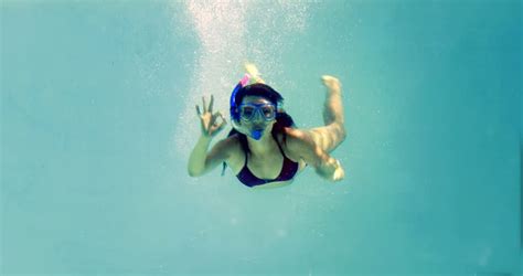 Pretty Brunette Swimming Underwater Into Pool With Snorkel On Her