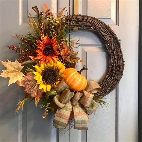 A Fall Wreath With Sunflowers Pumpkins And Leaves On The Front Door