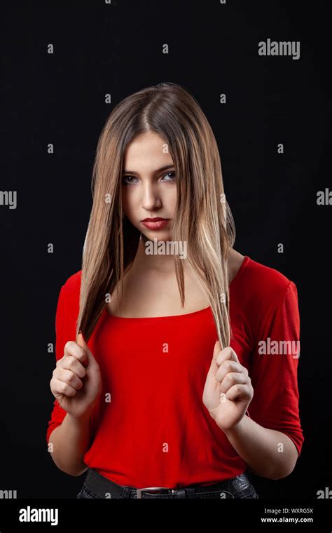 Beautiful Teenager Girl In Red Shirt Holding Her Hair On Black