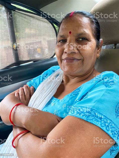 Closeup Image Of Indian Hindu Woman Sat In Back Of A Car With No Seatbelt Arms Crossed Wearing A
