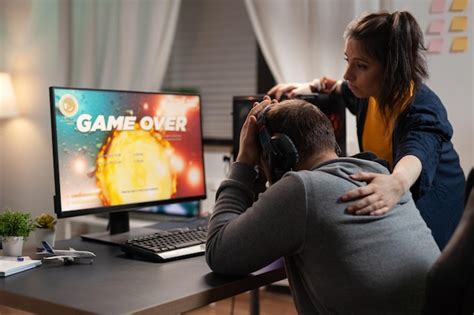 비디오 게임을 잃는 것에 대해 슬퍼하는 부부는 컴퓨터 앞에서 플레이합니다 온라인 게임 게임 장비와 헤드폰을 갖고 여가를 위해