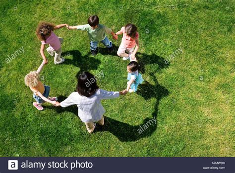 Teacher Playing Game Of Ring A Ring O Roses With Children 3 5 On Stock