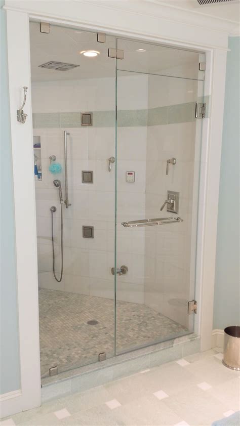 this steam shower has a flip transom above the door the panel is held in place with glass clips