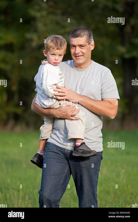 Father Carrying His Young Son In His Arms Stock Photo Alamy