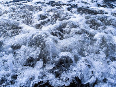 Wave Foaming On The Sand Closeup Of Sea Waves With White Foam On The
