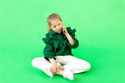 Una Niña De 8 Años Está Sentada Hablando Por Teléfono Foto Premium
