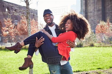 Man Carrying Woman And Laughing Stock Photo Dissolve