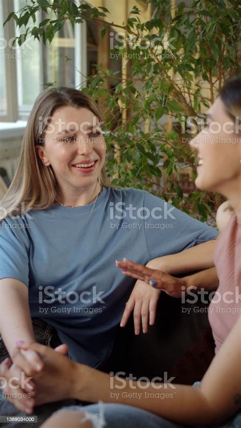 Lgbt Women Sit Together In The Living Room Talk To Each Other Holding