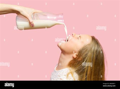 Happy Girl Drinking Milk From Bottle Isolated On Pink Background Milk Got By The Girls Mouth