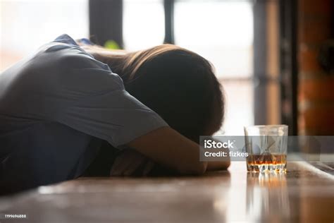 Drunk Young Woman Sleeping On Bar Counter Near Whiskey Glass Stock