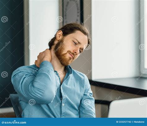 Tired Office Worker Suffering From Neck Pain In Office Stock Photo