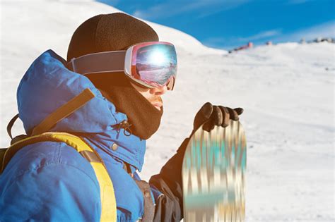 A Professional Snowboarder Stands With His Snowboard Closeup Portrait