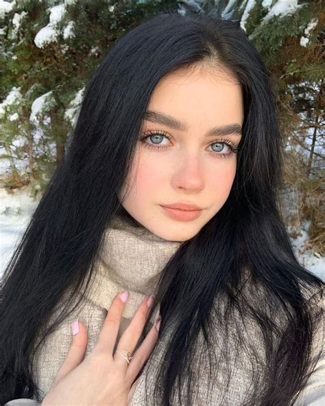 A Woman With Long Black Hair And Blue Eyes Is Taking A Selfie In The Snow