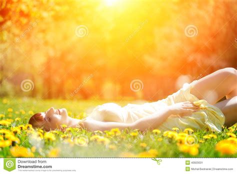 Young Beautiful Woman Lying On Grass Full Of Spring Flowers Relaxing