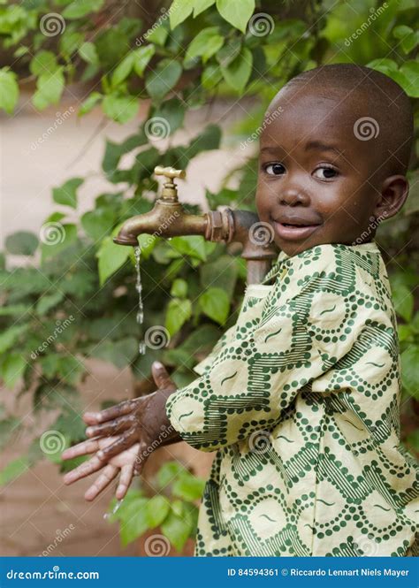 Young African School Boy Holding Hands Under A Tap Water Scarcity