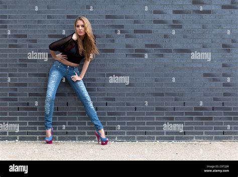 Junge Frau In Zerrissenen Jeans Schwarzes Top Und High Heels Posiert