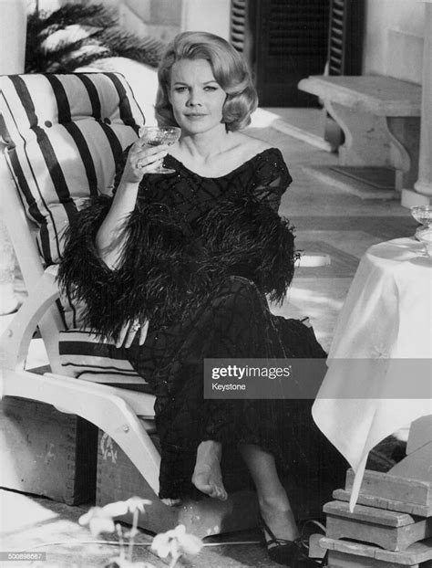 Actress Carroll Baker Relaxing On A Sun Lounger With A Drink On