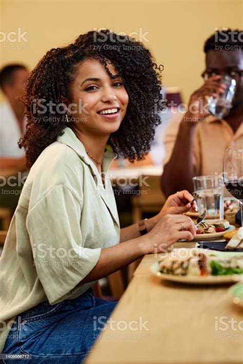 A Happy Hispanic Girl Sits In A Restaurant And Eating Her Lunch With